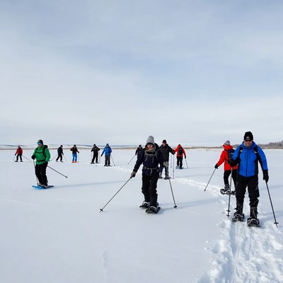 Group snowshoeing on frozen lake