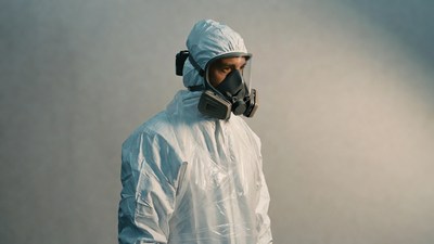Man in white hazmat suit and gas mask