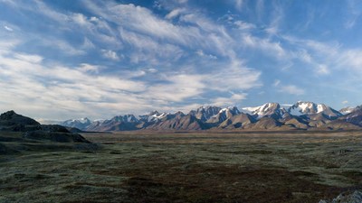 Snowy Mountains Over Vast Green Valley