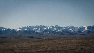 Snowy Mountain Range Over Brown Plains