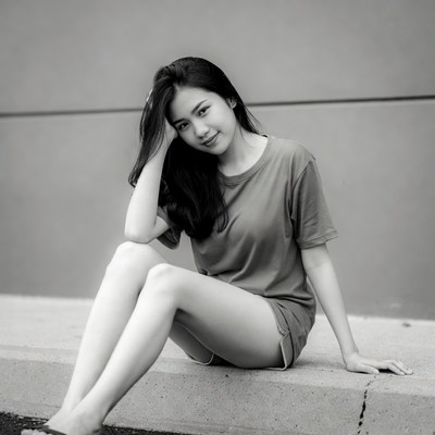 Asian woman sitting on concrete ledge