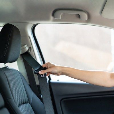 Woman buckling seatbelt in car