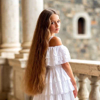 Girl in white dress at stone columns