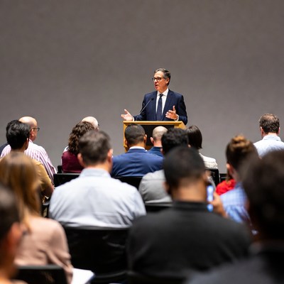 Man speaking at podium to audience