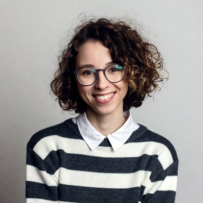 Smiling woman with curly hair and glasses