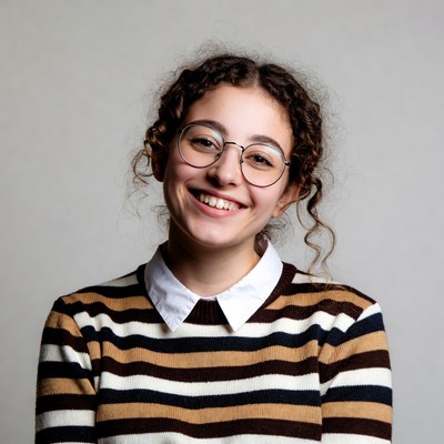 Smiling girl with curly hair and glasses