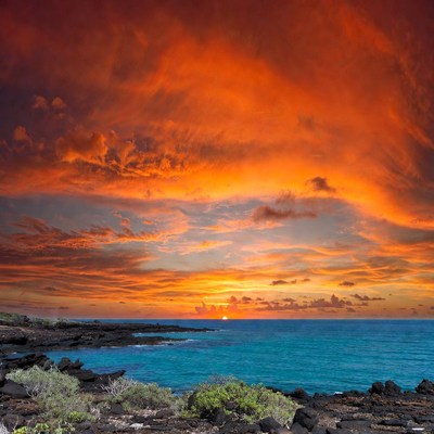 Vibrant Sunset over Ocean and Lava Rocks