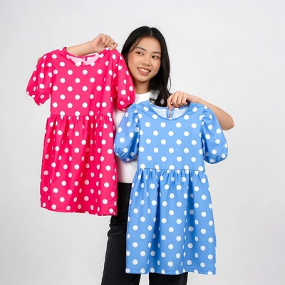 Asian woman holding pink blue polka dot dresses