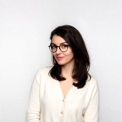 Woman with glasses smiling sideways