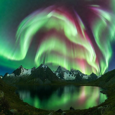 Northern Lights over Snowy Mountains and Lake