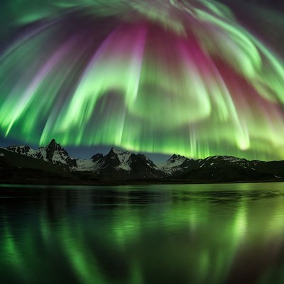 Northern Lights over Snowy Mountains and Lake