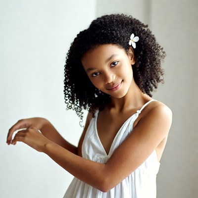 African-American girl with daisy in curly hair