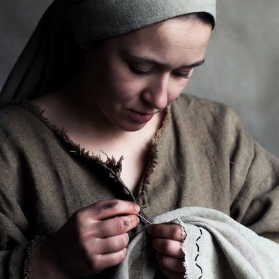 Woman sewing fabric with needle