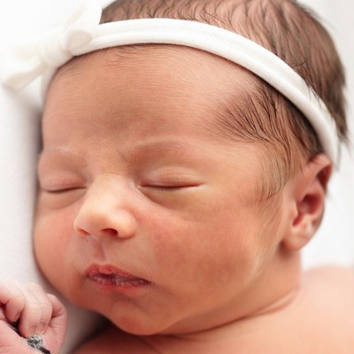 Sleeping newborn baby girl with headband