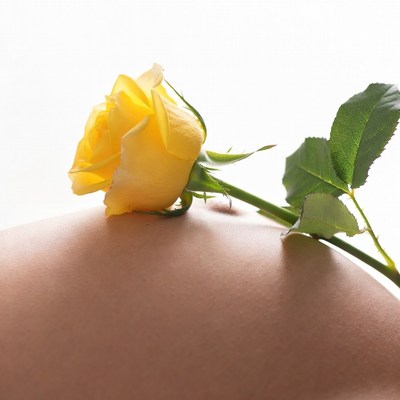 Yellow rose on woman's skin