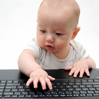 Baby typing on laptop keyboard