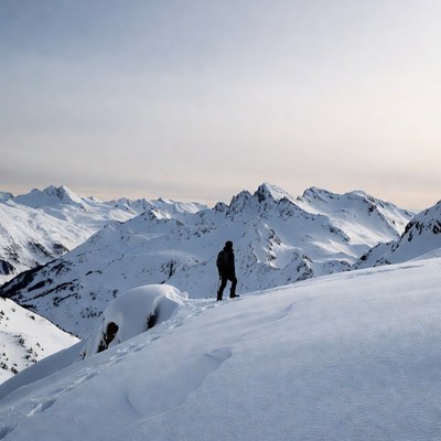 Man hiking snowy mountain ridge