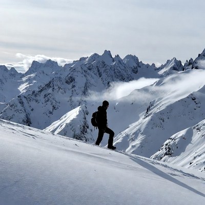 Hiker walking snowy mountain ridge