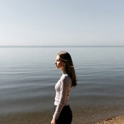 Woman standing by lake gazing away