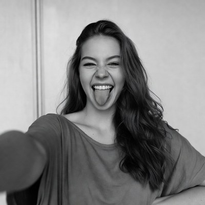 Young woman sticking out tongue selfie