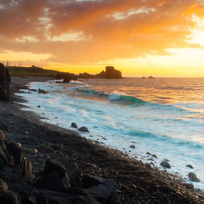 Ocean Waves Crashing on Rocky Beach at Sunset