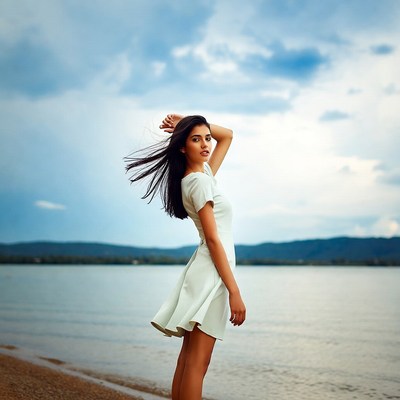 Woman in white dress by lake