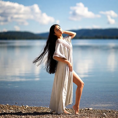 Woman in white dress by lake