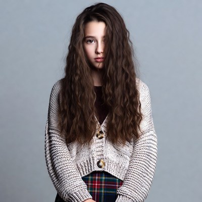 Teen girl in cardigan and plaid skirt