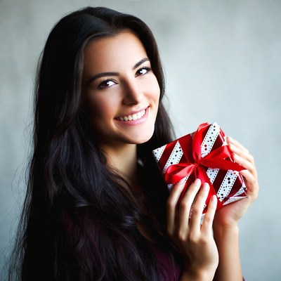 Smiling woman holding red gift box
