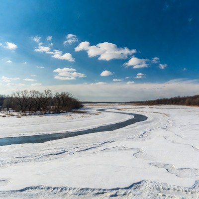 Winding Frozen River in Snowy Landscape
