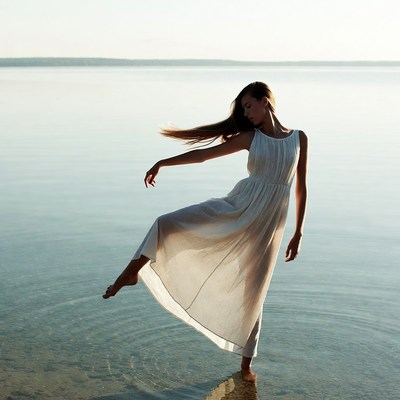 Woman dancing in white dress on lake