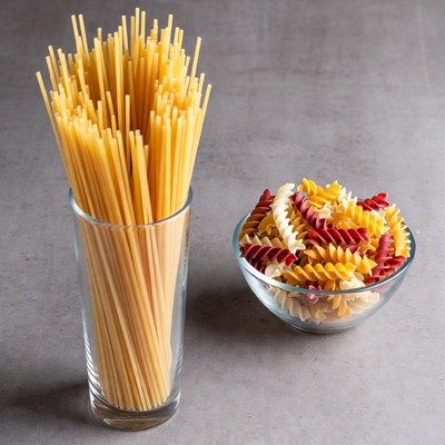 Spaghetti and Colored Pasta on Gray Background