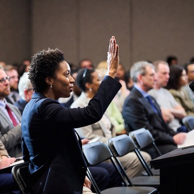 African-American woman raising hand in meeting