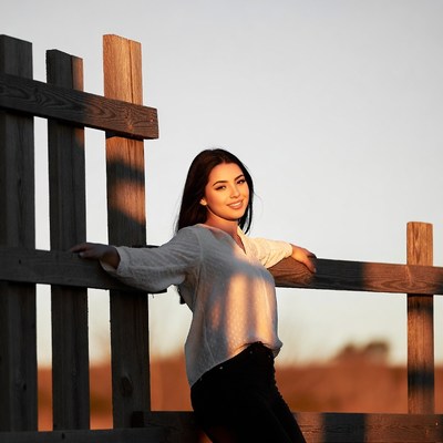 Asian woman leaning on wooden fence