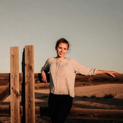 Woman leaning on wooden fence