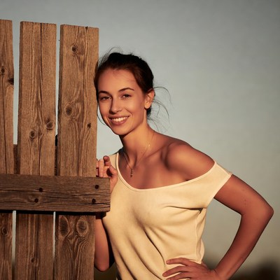 Smiling woman leaning on wooden fence