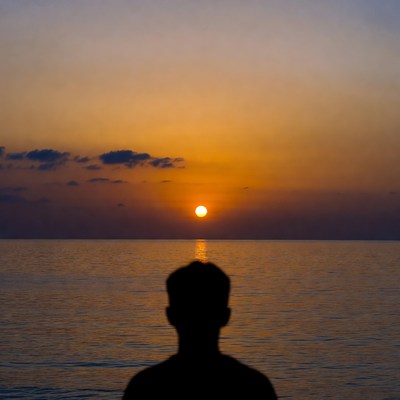 Man Silhouette Watching Sunset Over Ocean