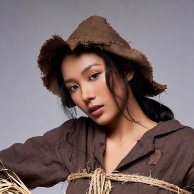 Asian woman in straw hat and brown outfit
