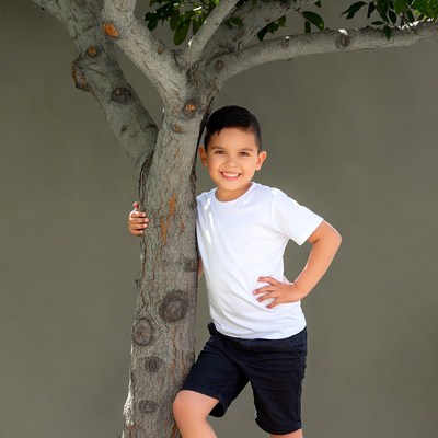 Boy smiling by tree
