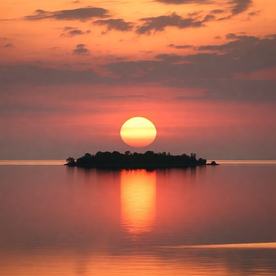 Sunset over island in calm lake
