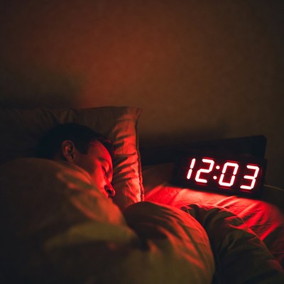 Man sleeping with red clock