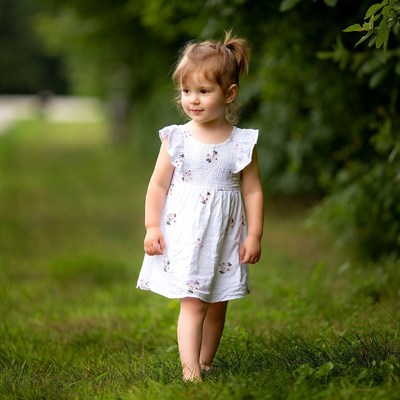 Toddler girl walking in green grass