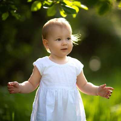 Baby girl in white dress outdoors
