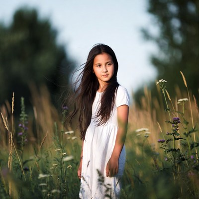 Young Asian girl in white dress in wildflowers