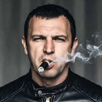 Man smoking cigar in leather jacket