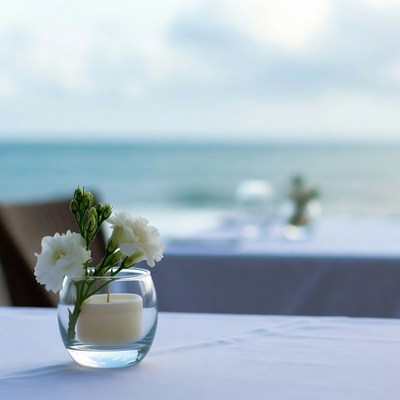 White Flowers in Candle on Beach Table