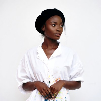 African-American woman in beret with paint-splattered shirt