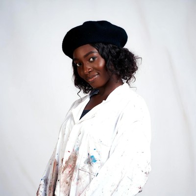 African-American woman in beret and paint-splattered shirt