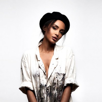 Woman in beret and paint-splattered shirt