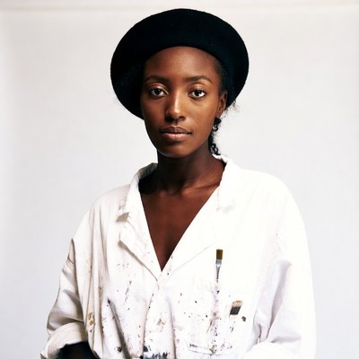 African-American woman in beret and paint-splattered shirt